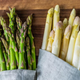 Green and white asparagus on wood surface